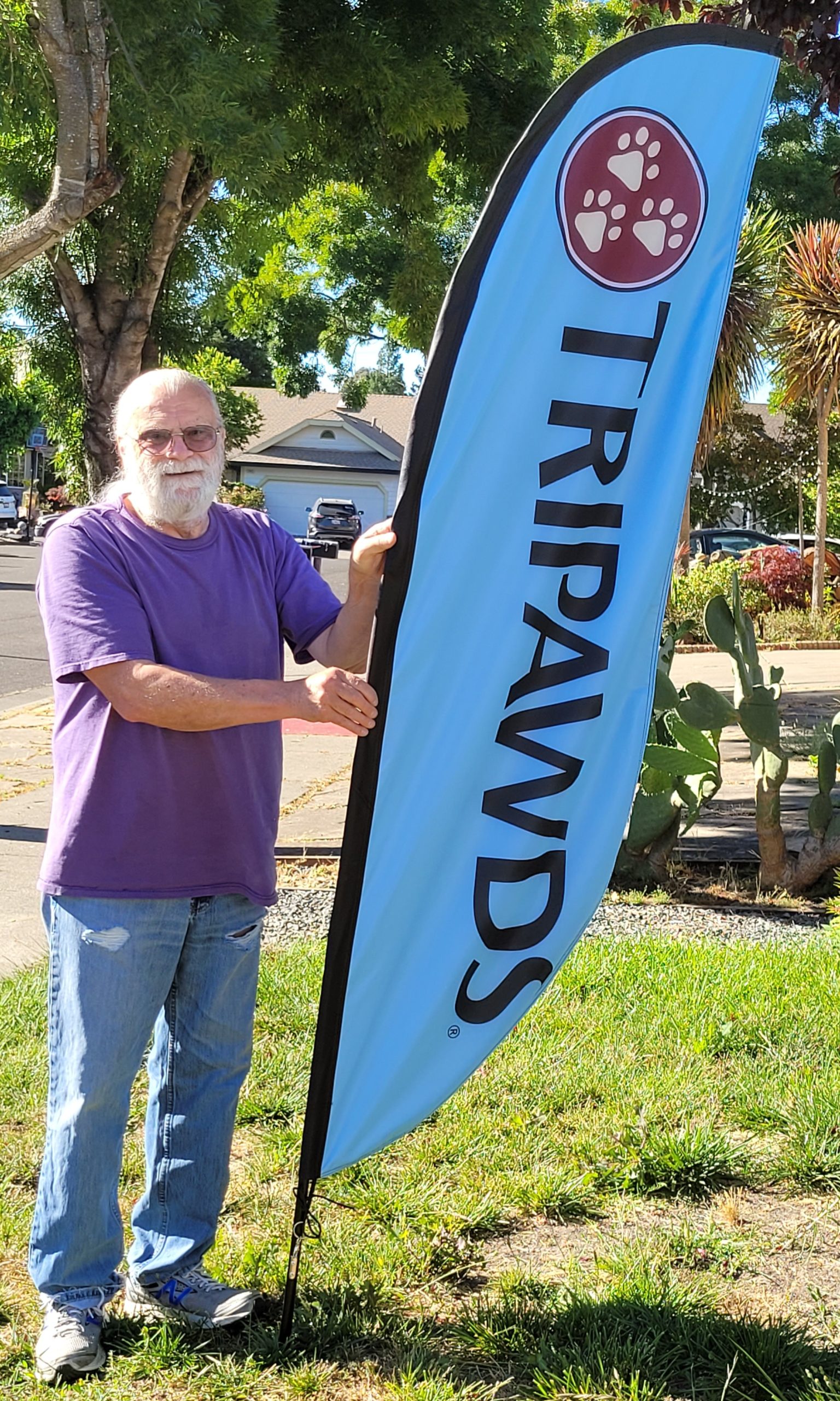 Jack holds Tripawds banner for 3-legged dog picnic in San Francisco